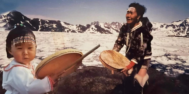 Anna Kûitse Thastum and her grandddaughter playing the Inuit frame drum qilaat. Photographer unknow Anna Kûitse Thastum and her grandddaughter playing the Inuit frame drum qilaat. Photographer unknow